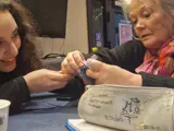 Mette helping Leyla with knitting