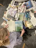 Girl surrounded by journals and newspapers