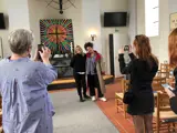 People taking pictures of an art piece in church